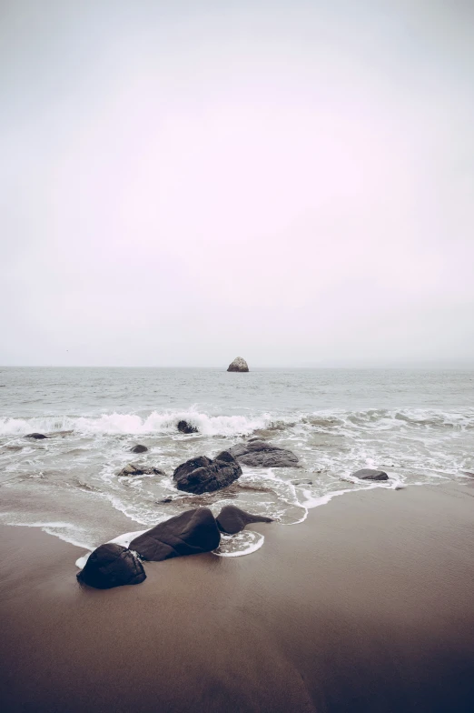 a couple rocks that are sitting in the sand