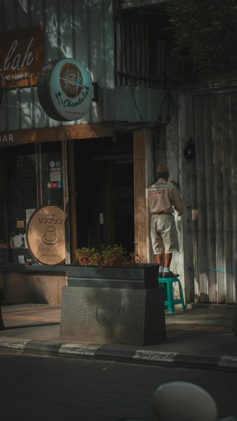 an image of a man standing on a chair on the street