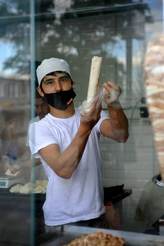 a man making pizza with a giant black mustache