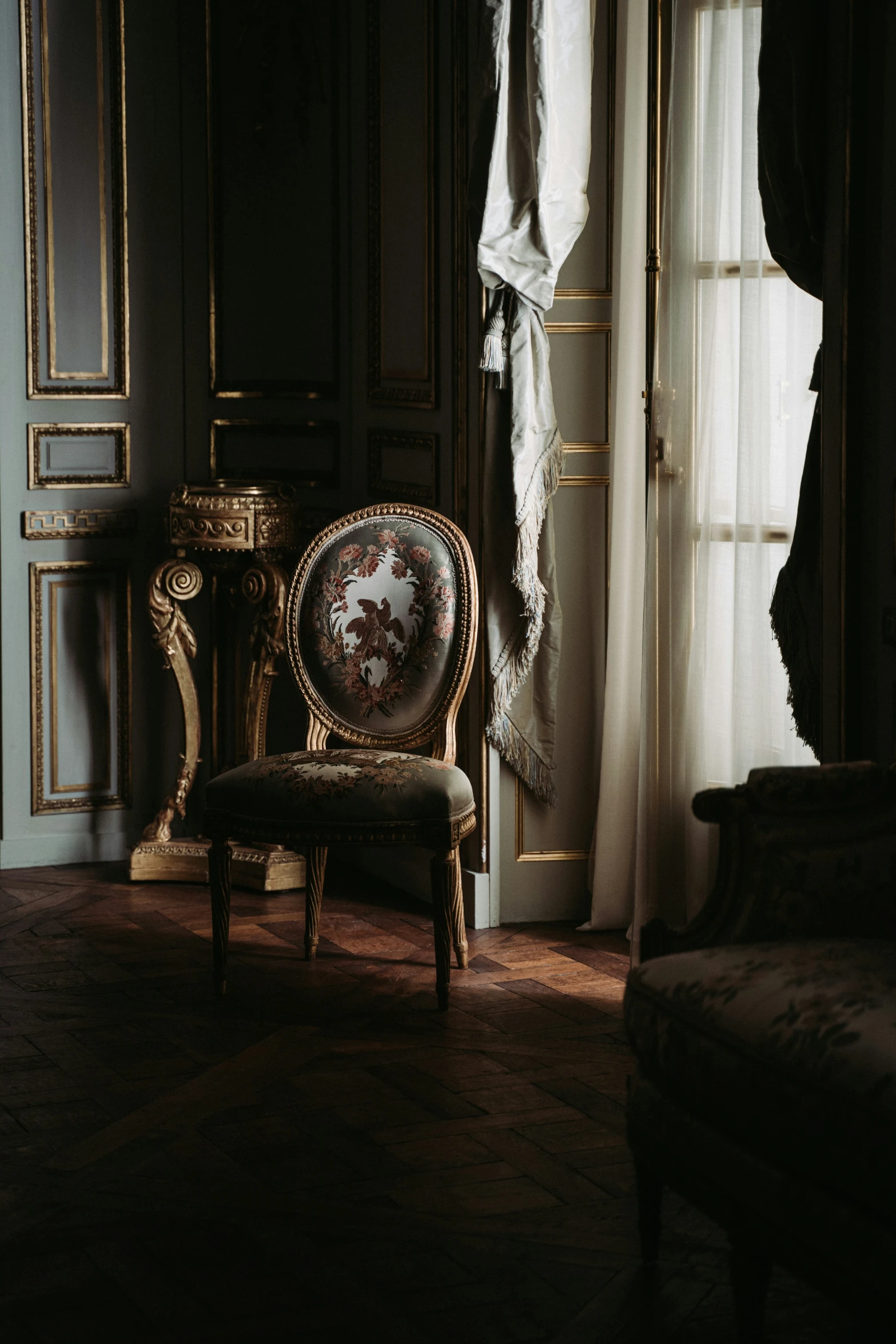an antique chair is in front of a large window