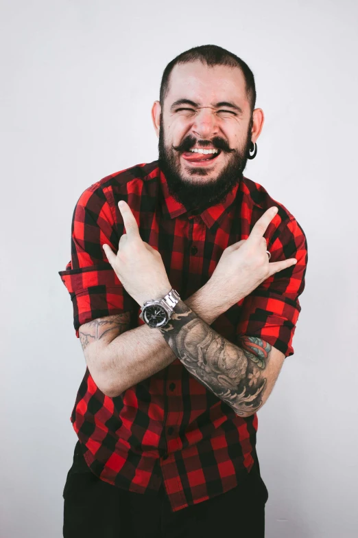 a bearded man with a watch making a sign