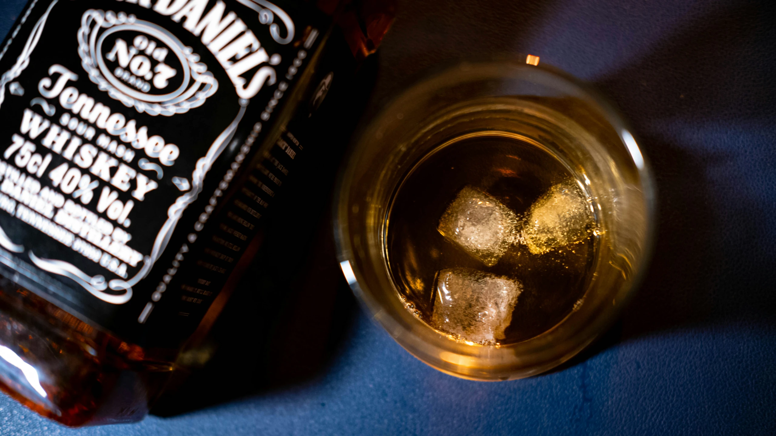 a glass of whiskey sitting next to a bottle