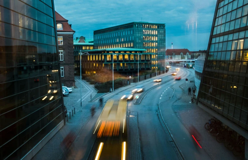 night view from high up of buildings with long exposure of cars moving down the road