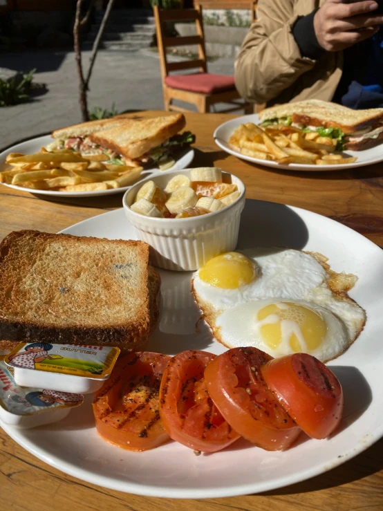 this meal consists of fried eggs, toast and tomatoes