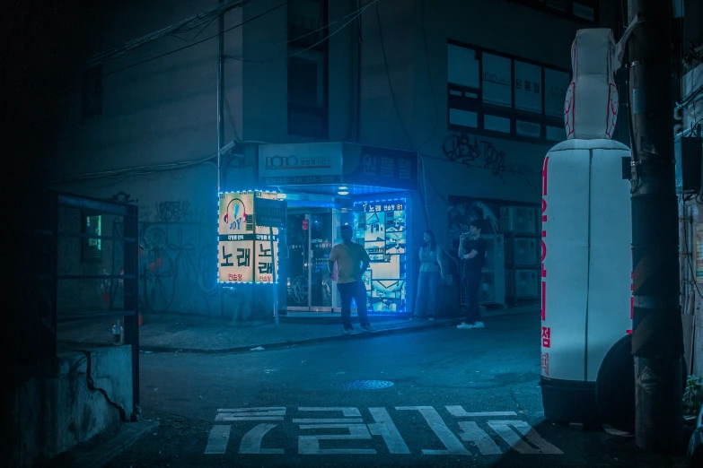 a man stands outside a neon store at night