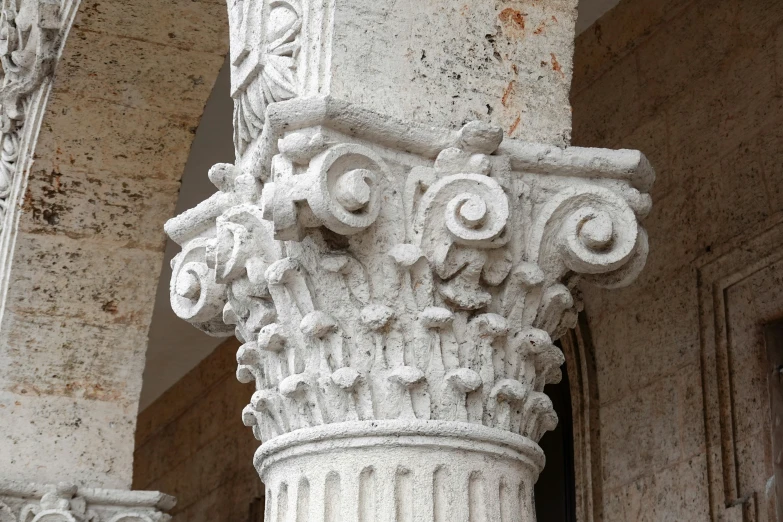 some white ornately decorated pillar and some buildings