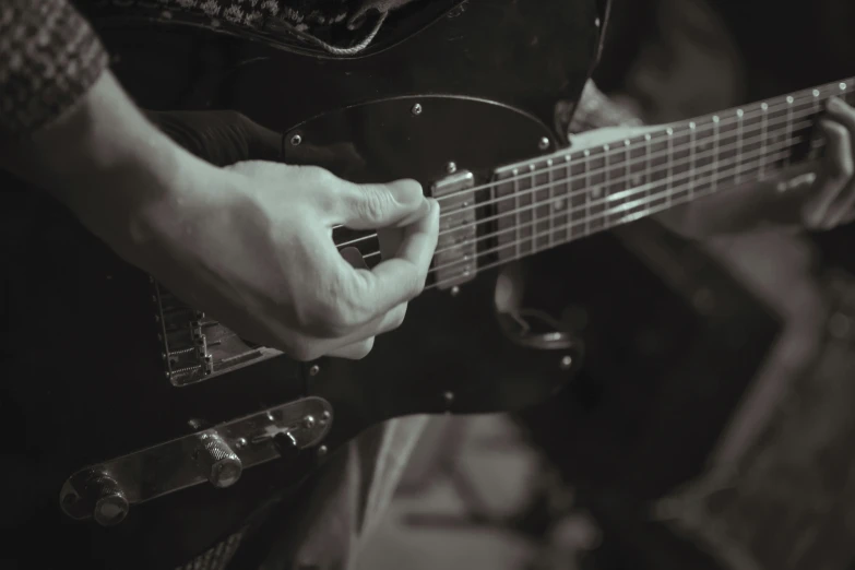 a hand holding a guitar that is playing on stage