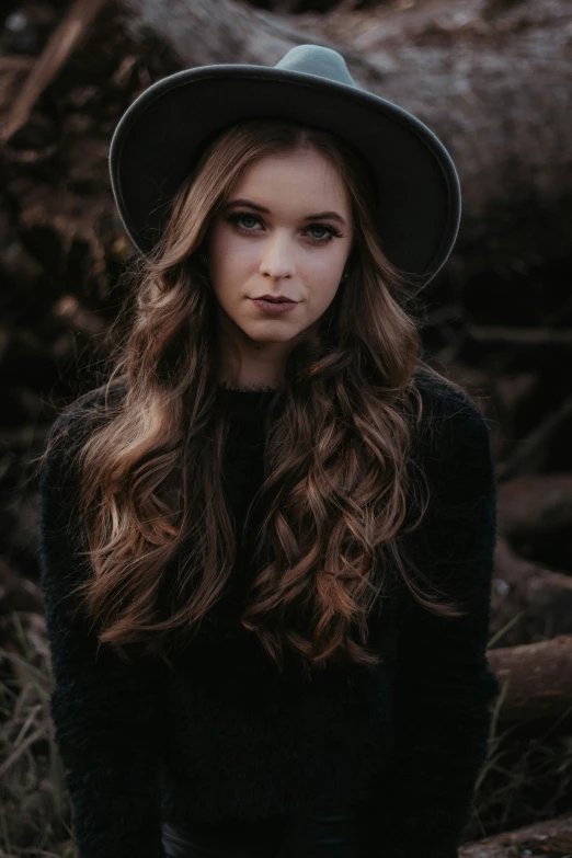 the girl has long hair wearing a black hat