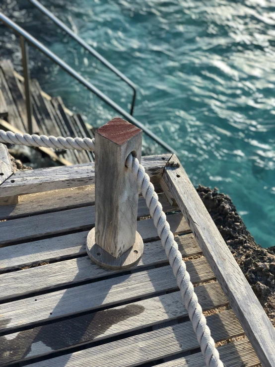 roped ends of boat dock next to water