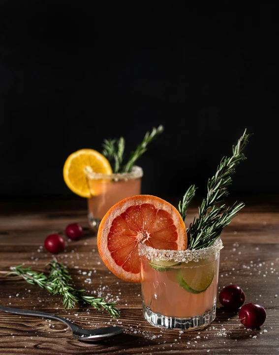 two glasses filled with ice, lemons and garnish