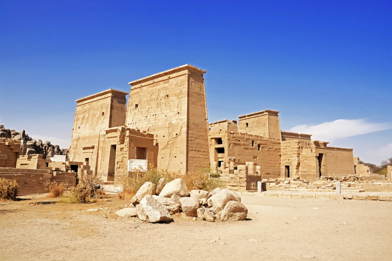 a group of buildings in the desert with rocks