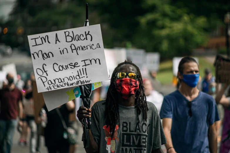 a person holding a sign that says i'm a black man'n america of course him pyropic will prevent