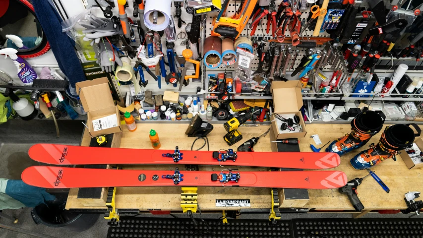 a red snowboard with black wheels on a table