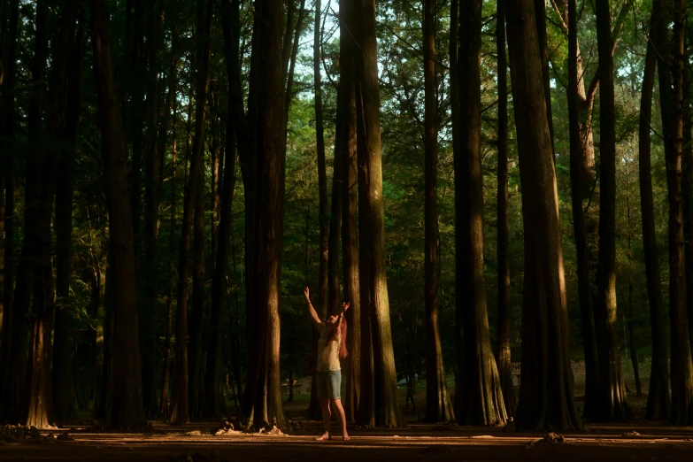 a man holding his arms in the air and wearing shorts