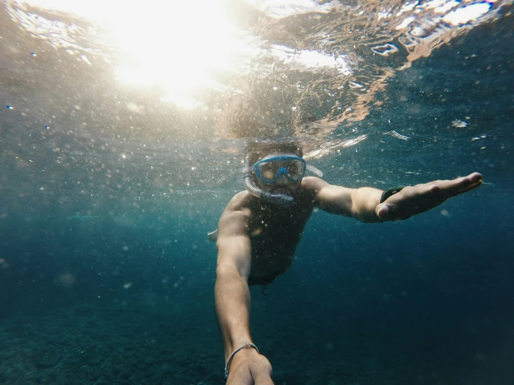 a young man swimming in the water with his arm outstretched