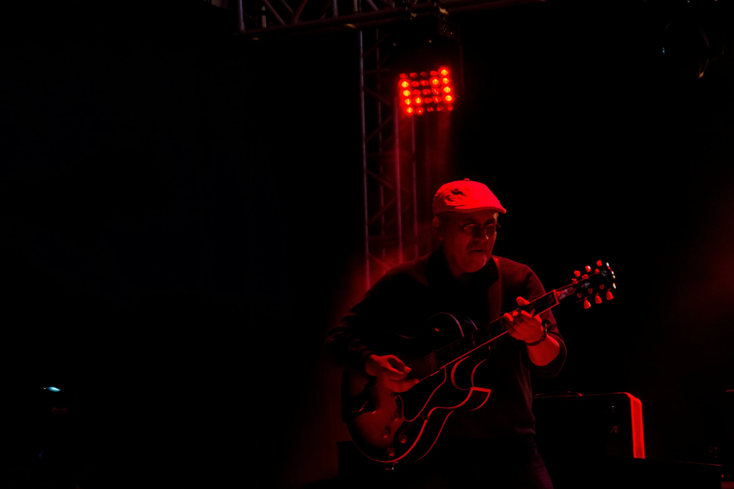 a man that is playing guitar in the dark