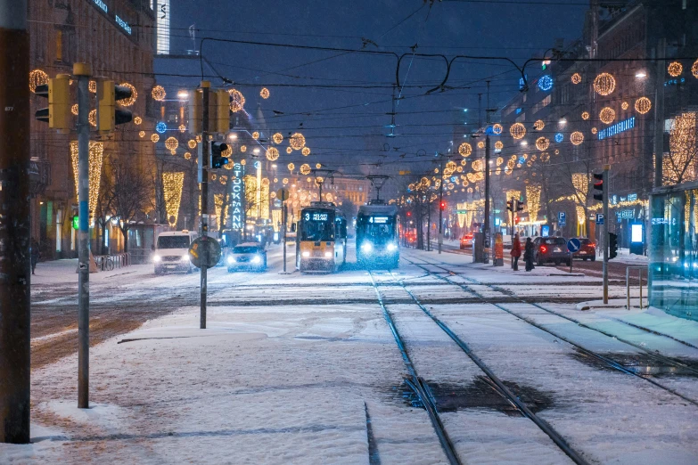 snowy street in a large city with street lamps and snow