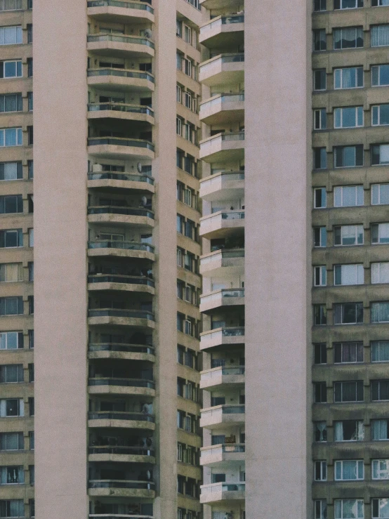 a very tall building with multiple stories surrounded by other tall buildings