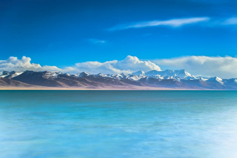 the beautiful blue ocean with white snow on the mountains