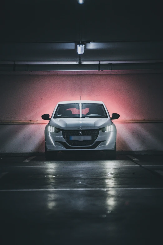 a white car parked in front of a red wall