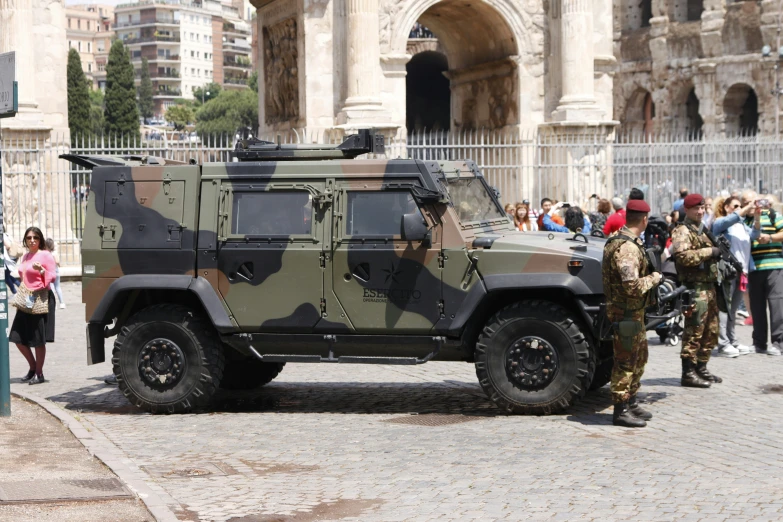 two soldiers standing in front of a military vehicle