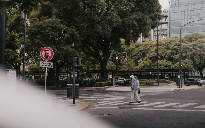 a man crossing a street with cars parked next to him