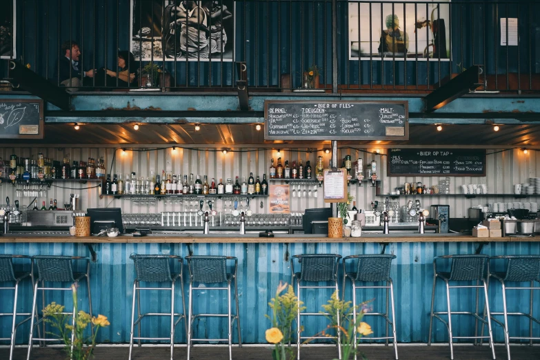 a bar with seating and chalkboards hanging on the wall