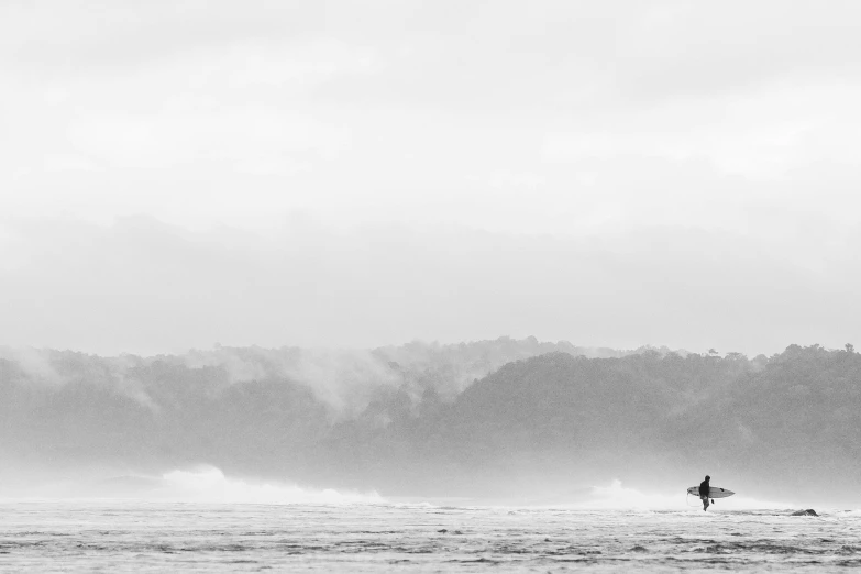 a surfer holding his board in the water