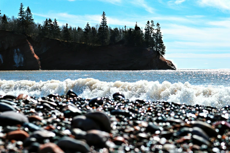 an ocean that has some rocks and sand on it