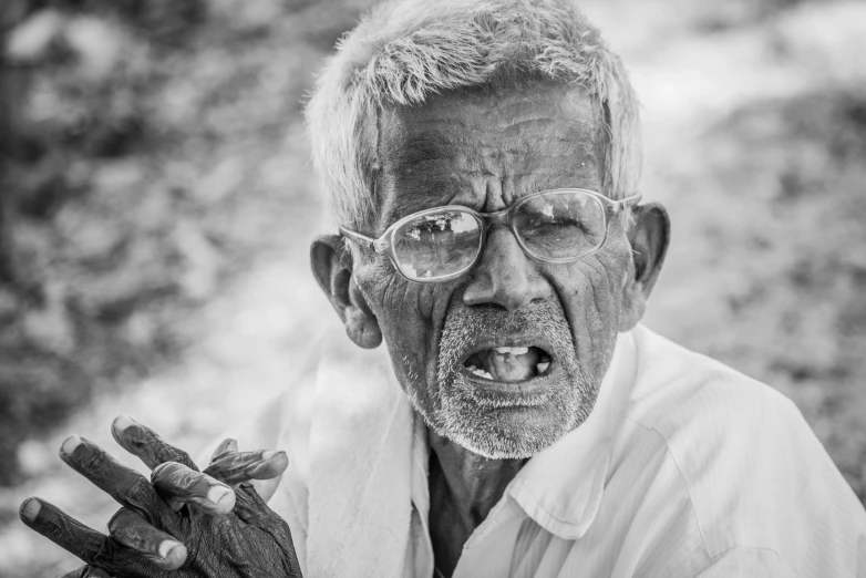 an old man with a surprised expression holding his hand up