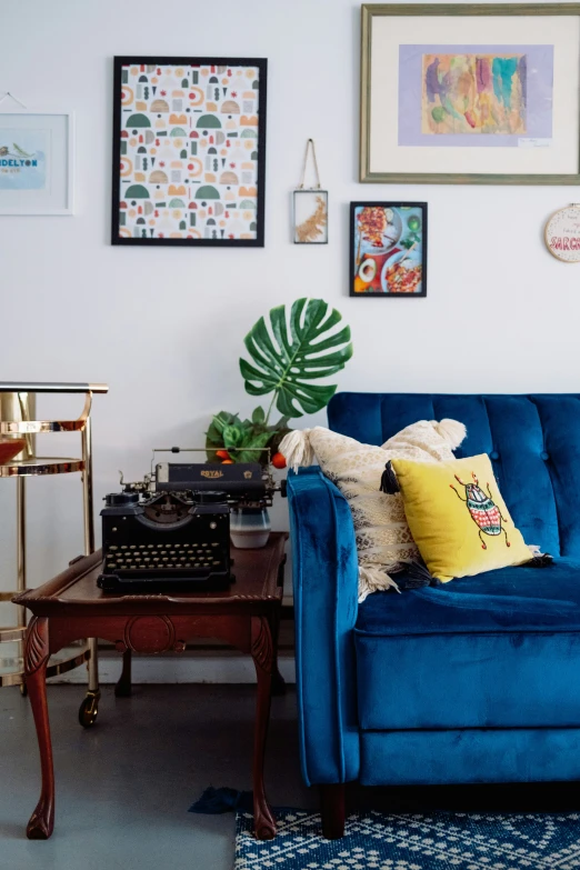 a blue couch sitting in a living room next to a table