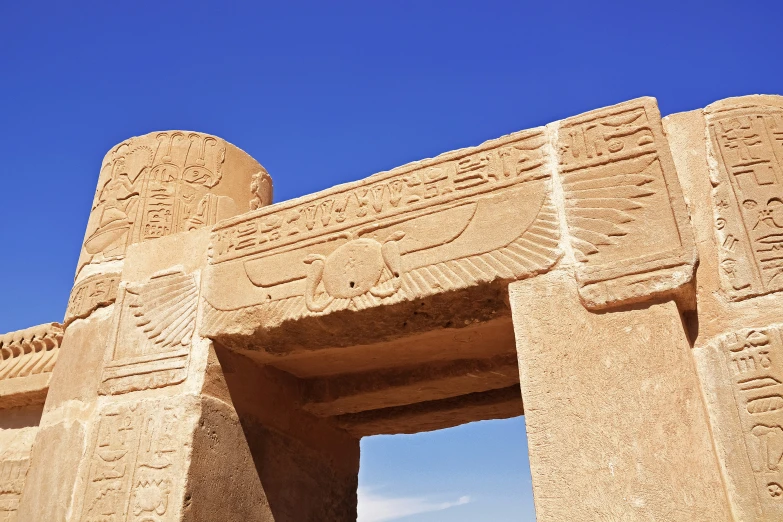 an ancient egyptian architecture in egypt with a blue sky