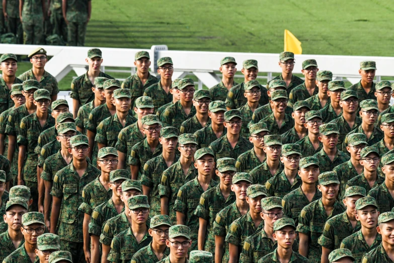 a large group of men and women in green camouflage