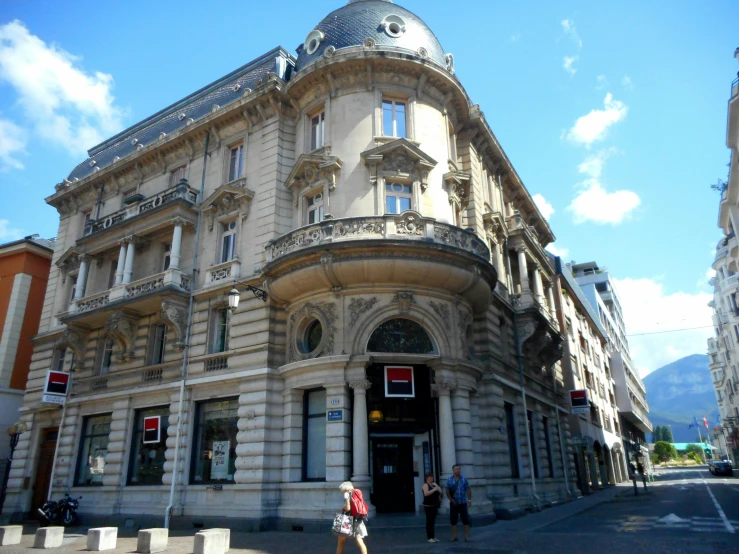 a man and woman walk by the entrance of a building