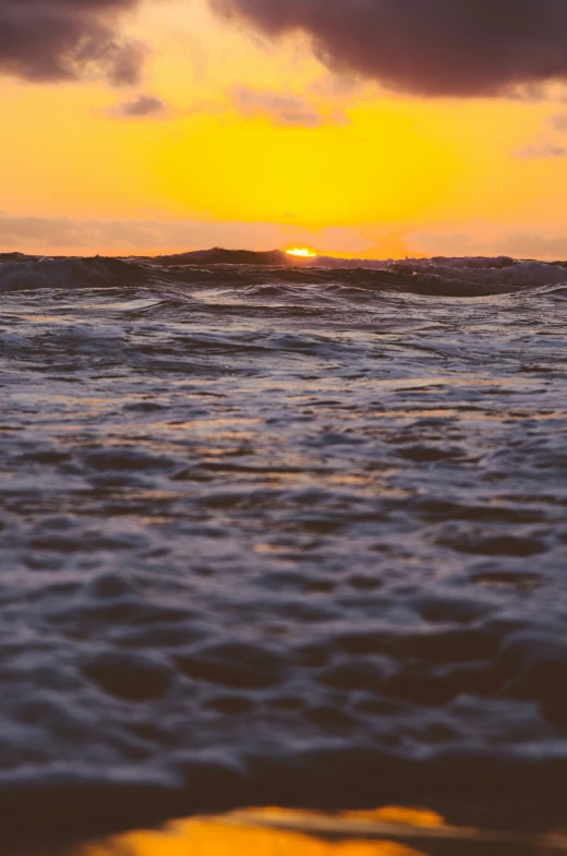 the sun is shining over the water of a beach