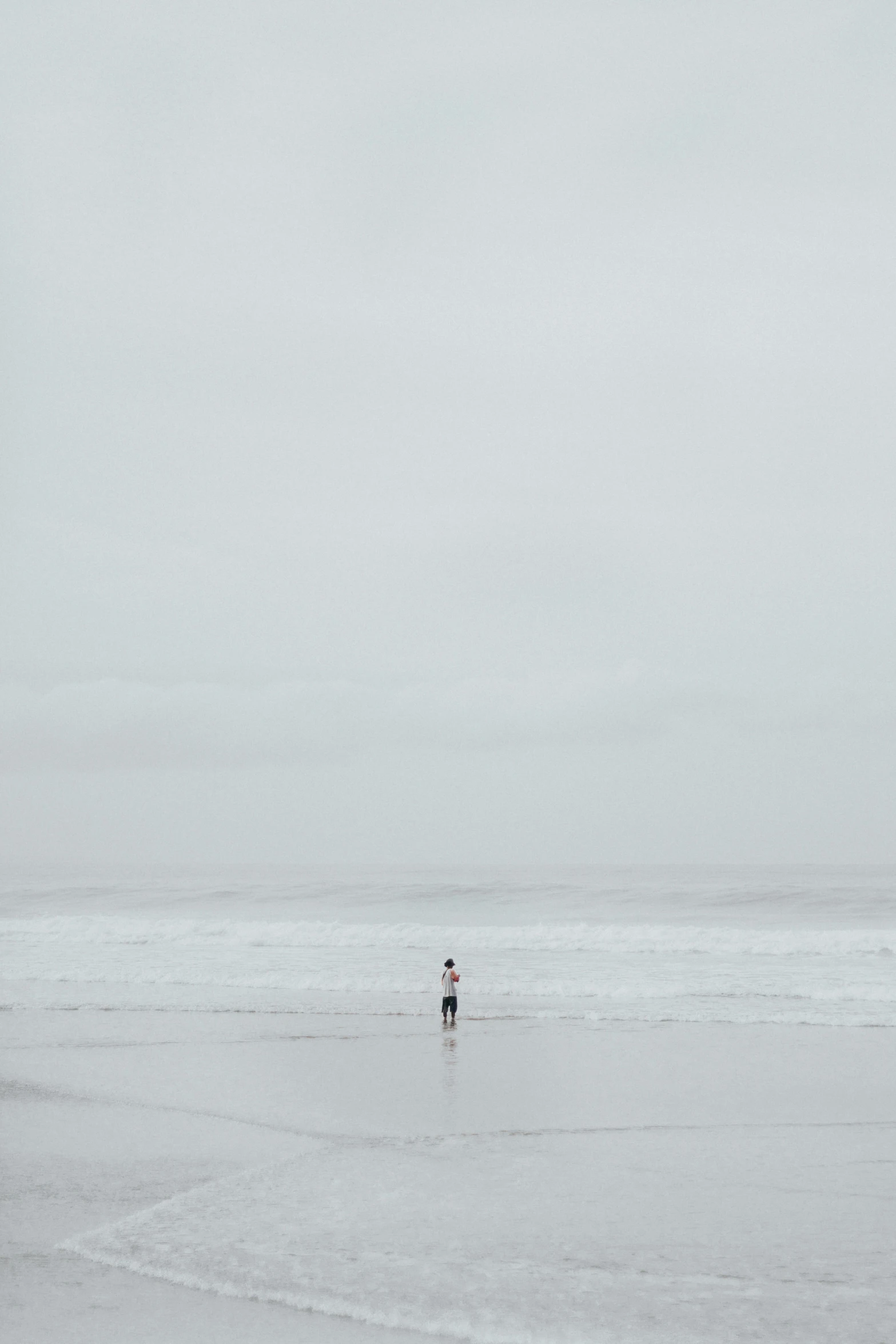 a person is walking along a beach holding an umbrella