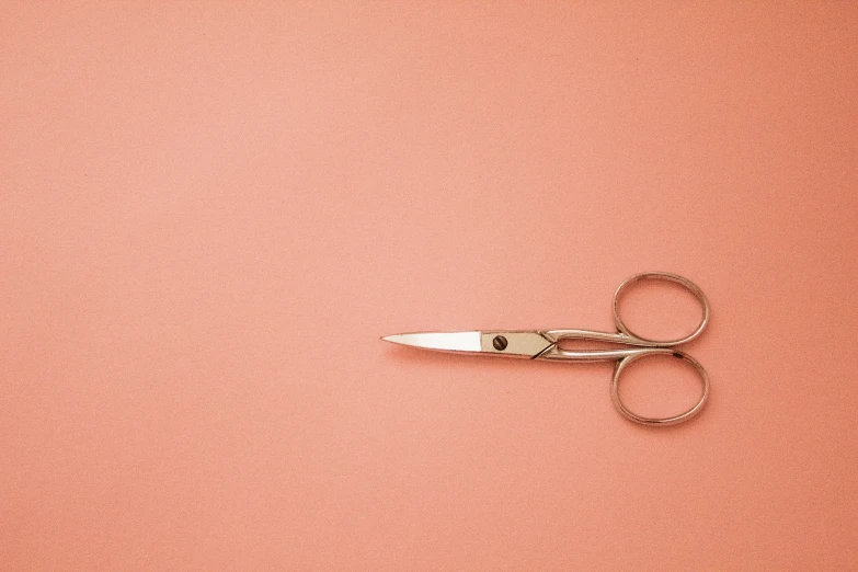 a pair of scissors with a cord on it on an orange background