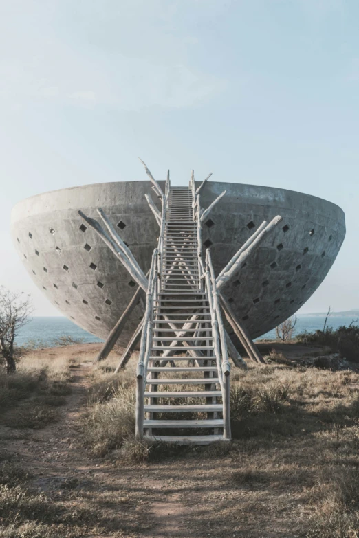 an old ship is in a dry grassy area and it's staircase to the side