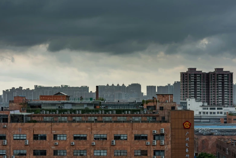 the tops of tall buildings are in a cloudy sky