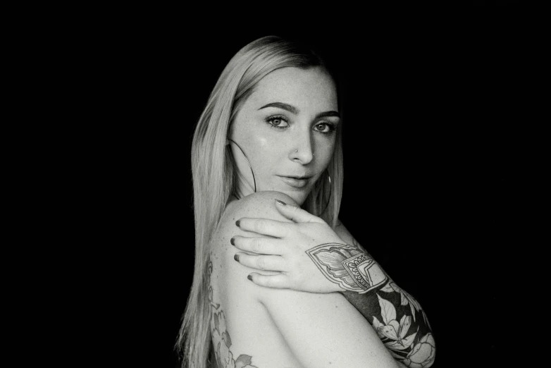 a young woman with long hair wearing tattoos