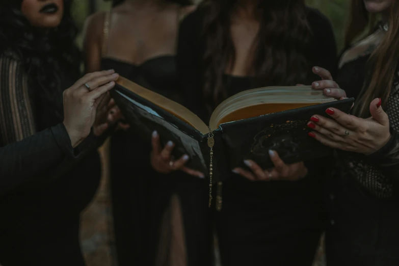 a group of women standing around a book