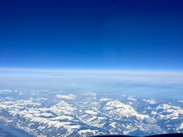 a po taken from an airplane looking down at snow capped mountains