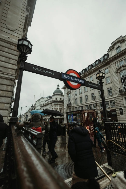 a street sign at a station showing direction to various shops