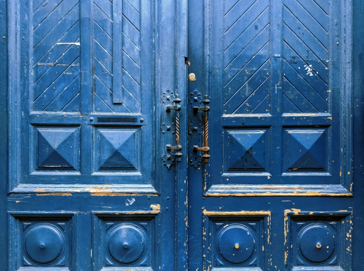 the blue doors to this building have an ornate design on them