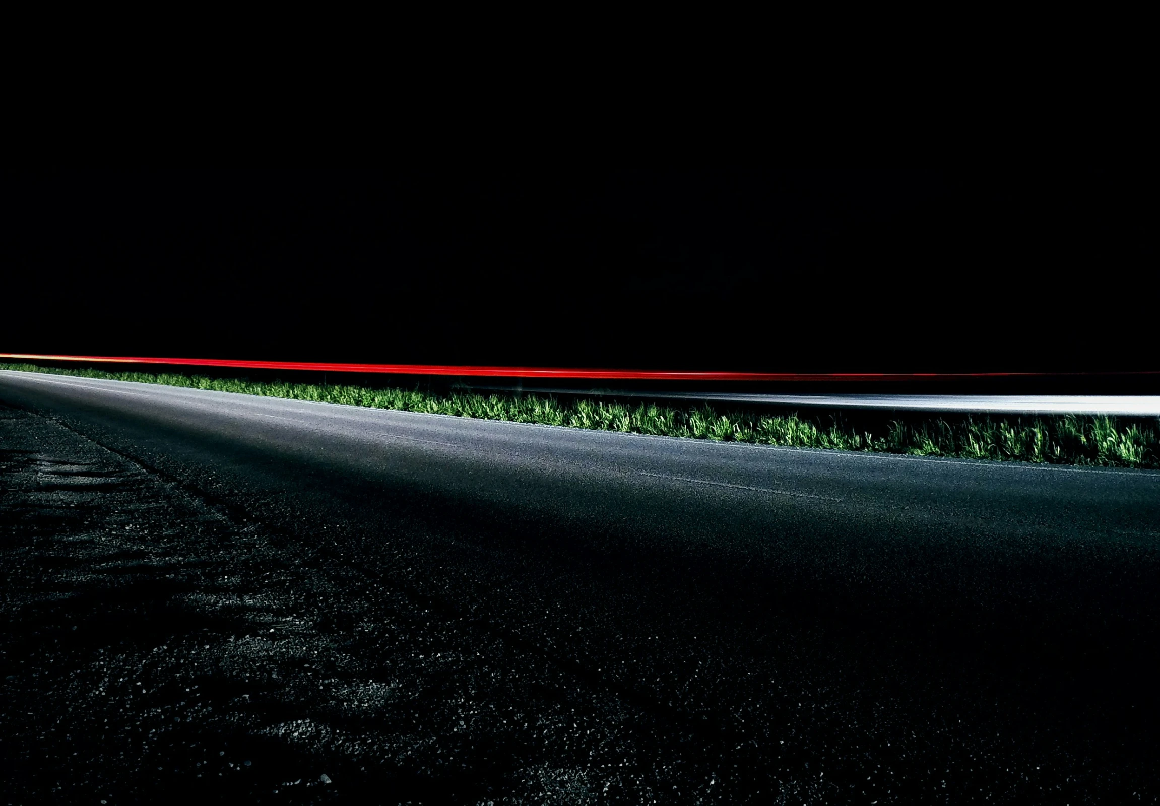 a very long narrow street lined with grass