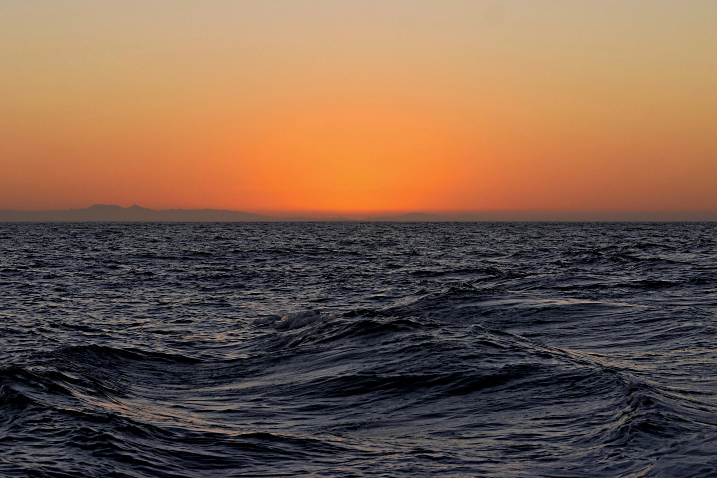 the sun is setting over the ocean and some water