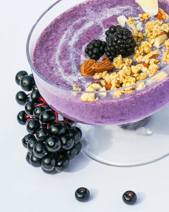 a bowl full of fruit with granola, bananas and blueberries