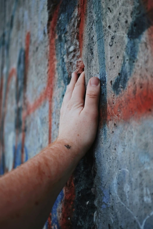 the hand is touching the wall with spray paint
