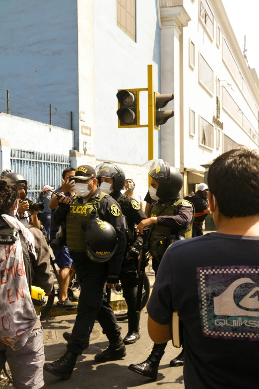 several people in full riot gear walking away from the police