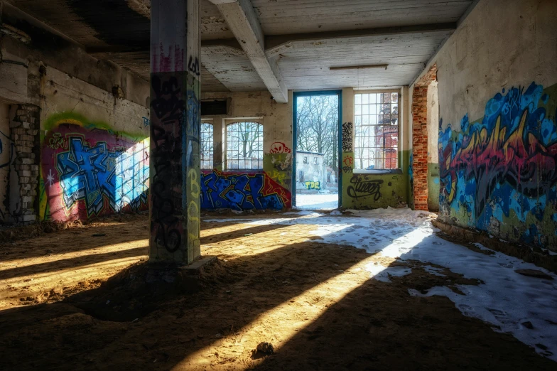 a room in a abandoned building with graffiti all over the wall